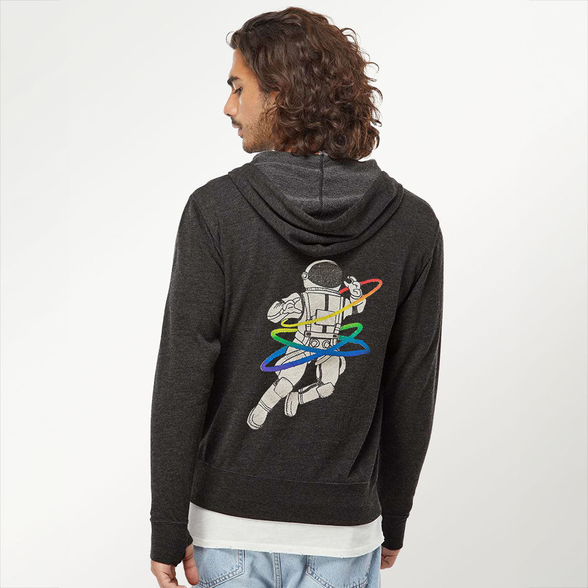 a photo of the back of a brown haired man wearing a dark heather grey hooded sweatshirt featuring a rainbow gay astronaut graphic