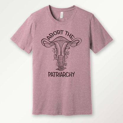 orchid colored t-shirt with a black screen printed floral uterus graphic and "abort the patriarchy" text