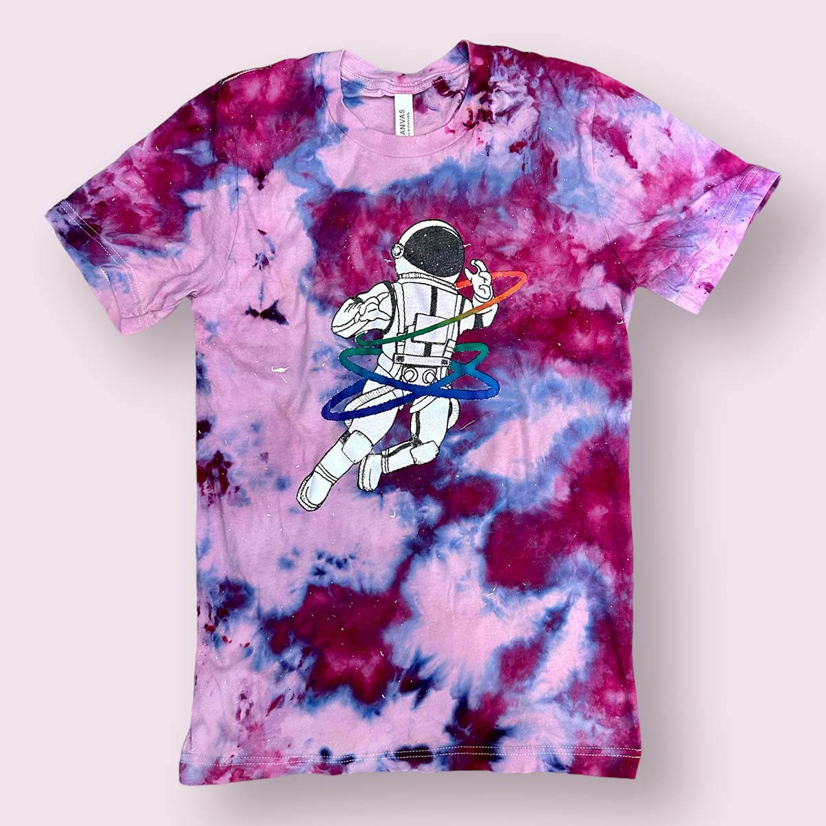 galaxy tie-dyed t-shirt speckled with paint featuring a rainbow gay astronaut graphic